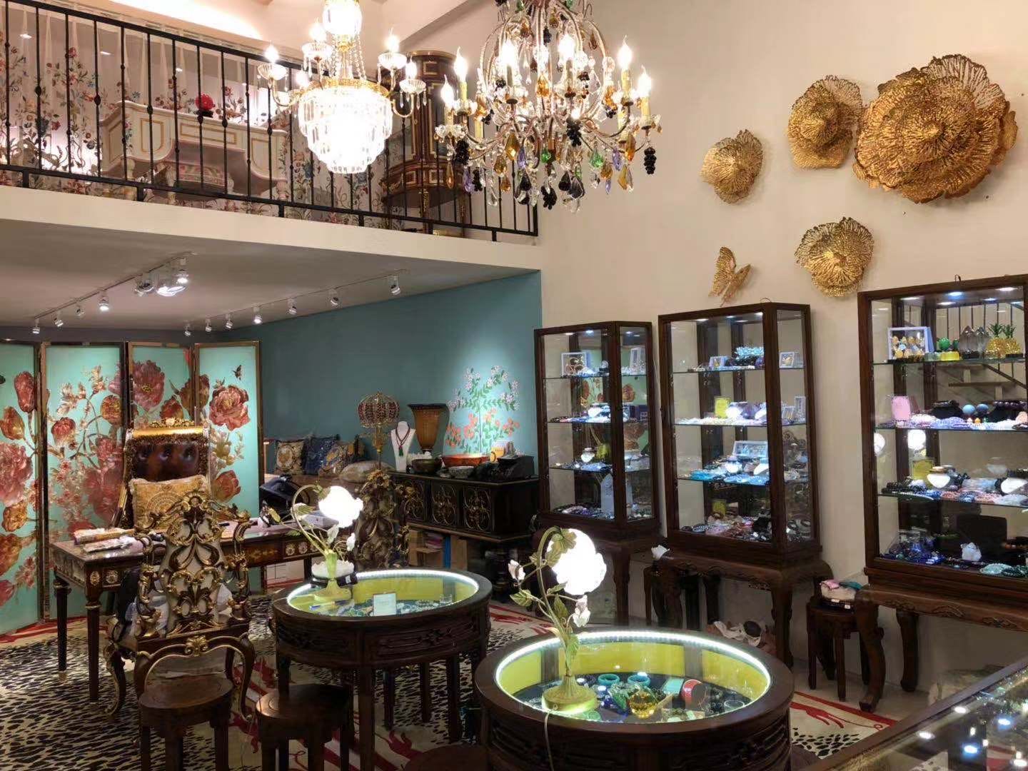 媧石皇家臺北店內實景：水晶吊燈、金色壁飾、玻璃展示櫃與花卉屏風